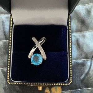 White gold “enhancer”/pendant with blue stone.